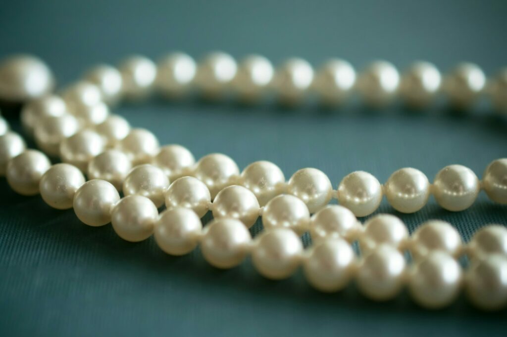 a strand of creamy white pearls on a soft blue background